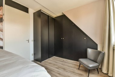 Modern minimalist tarzda pencereli mansard yatak odasındaki yeşil duvarın yanına konforlu yatak