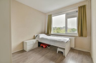 Kareli battaniyeyle kaplı rahat bir yatak ve modern dairenin aydınlık yatak odasında.