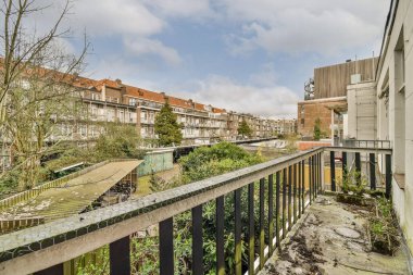 Eski tuğlalı binaların ve bisikletli arabaların ön manzarası küçük balkondan tırabzanlara kadar uzanıyor.