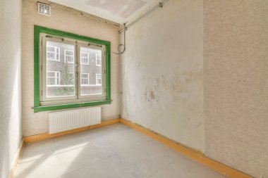 Evdeki boş ışık odasında, beyaz duvardaki plastik pencere ve radyatör.