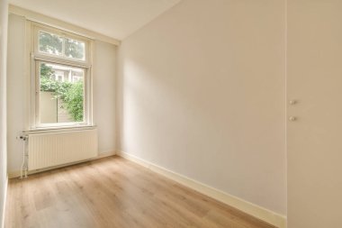 Evdeki boş ışık odasında, beyaz duvardaki plastik pencere ve radyatör.