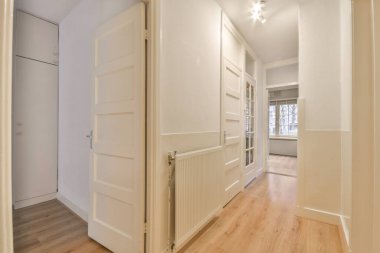 Dar, boş koridor lambalarla aydınlatılmış, minimal tarzda modern dairenin içi