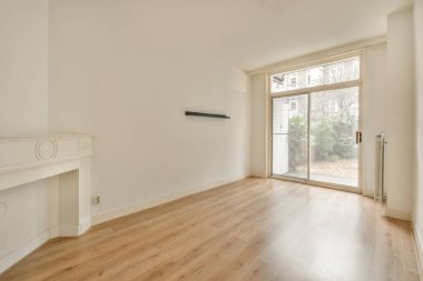 Evdeki boş ışık odasında, beyaz duvardaki plastik pencere ve radyatör.