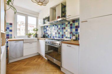 Köşedeki dolaplar ve sandalyeli masa günümüzün düz mutfağında.