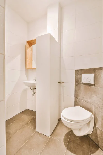 Wnętrze Wąskiej Toalety Umywalką Toaletą Ścienną Białymi Ścianami Podłogą Kratkę — Zdjęcie stockowe