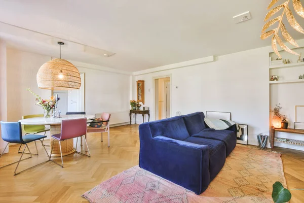 Modern apartmandaki dekorasyonlu ve televizyonlu, rahat koltuğun yanına yerleştirilmiş eski püskü ahşap masa.