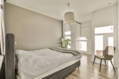 Konforlu yatak ve duvarın yanındaki sandalyeler. Çerçeve yatak odasındaki çerçeveli resimler.