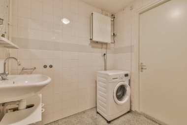 Tuvaleti duvara asılmış beyaz fayanslı banyoda lavabo ve ayna dolabı.