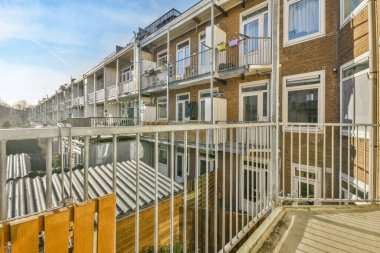 Eski tuğlalı binaların ve bisikletli arabaların ön manzarası küçük balkondan tırabzanlara kadar uzanıyor.