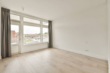 Evdeki boş ışık odasındaki plastik pencereler ve beyaz duvarlar.