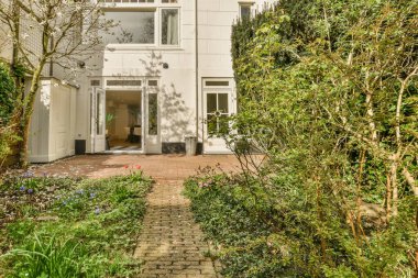 Ahşap çitlerin yanında küçük bahçesi olan basit küçük bir teras.