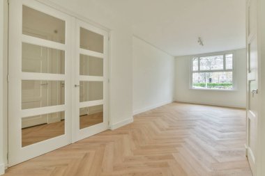 Perdeleri ve ahşap parke zemini olan büyük pencereli boş beyaz odanın içi.