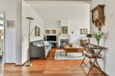 Rahat koltuklar ve ahşap masa modern dairenin oturma odasının penceresinin yanındaki saksı bitkilerinin yanına yerleştirildi.