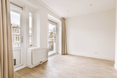 Evdeki boş ışık odasında, beyaz duvardaki plastik pencere ve radyatör.