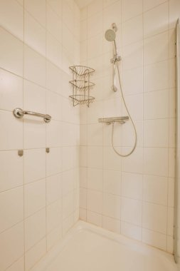 Duş muslukları cam bölmenin yanındaki fayanslı duvara bağlı ve evdeki tuvaletteki süs pervazı.
