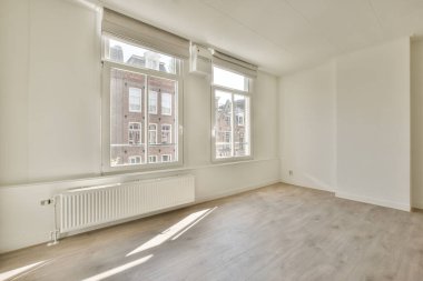 Evdeki boş ışık odasında, beyaz duvardaki plastik pencere ve radyatör.