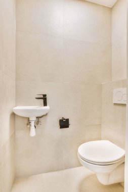 Lavabolu ve duvarlı, beyaz duvarlı ve kareli tuvaletli dar bir tuvalet.