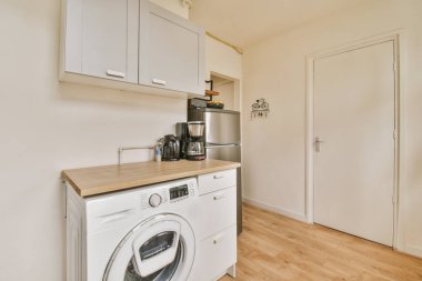 Minimalist tarzı beyaz mobilyalı, lavabolu ve sobalı bir ev mutfağı.