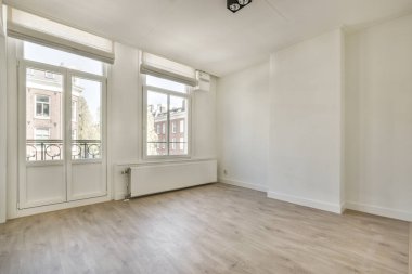 Evdeki boş ışık odasında, beyaz duvardaki plastik pencere ve radyatör.