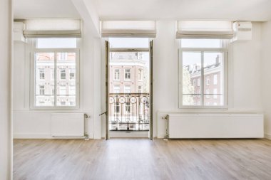 Evdeki boş ışık odasında, beyaz duvardaki plastik pencere ve radyatör.