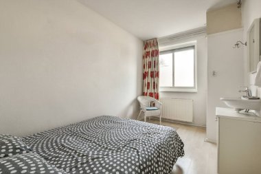 Küçük, minimalist, beyaz duvarlı yatak odasına konforlu yatak ve lamba modern dairede ayna ile batıyor.