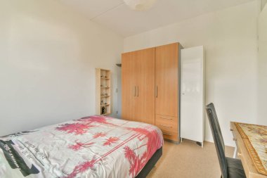 Yatak odasının iç tasarımı, yatak odası ve ahşap gardırop modern dairenin penceresinin kenarına yerleştirilmiş.