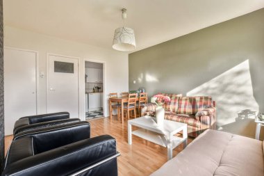 Büyük pencerenin yanında kanepesi olan basit pahalı bir oturma odası.