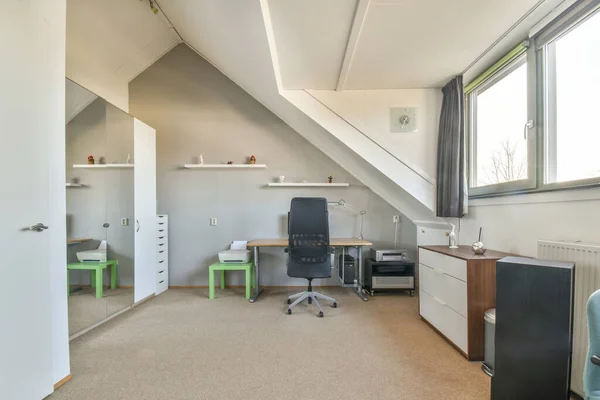 現代のアパートの光の職場でコンピュータモニターとホワイトボードと机の近くに配置快適な椅子 — ストック写真