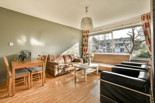 Simple expensive interior of living room with sofa near big window