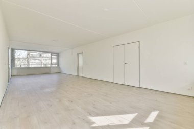 Evdeki boş ışık odasında, beyaz duvardaki plastik pencere ve radyatör.