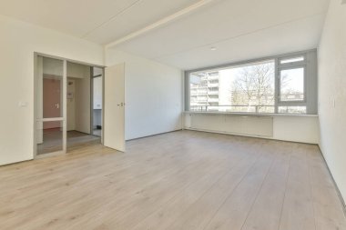 Evdeki boş ışık odasında, beyaz duvardaki plastik pencere ve radyatör.