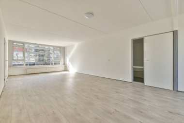 Evdeki boş ışık odasında, beyaz duvardaki plastik pencere ve radyatör.