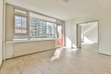 Evdeki boş ışık odasında, beyaz duvardaki plastik pencere ve radyatör.