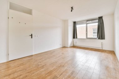 Evdeki boş ışık odasında, beyaz duvardaki plastik pencere ve radyatör.