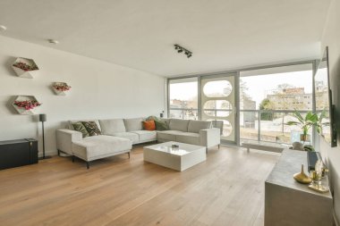 Günümüz minimalist tasarımı. Hafif stüdyo dairesinin ahşap masası ve oturma odası ile beyaz duvarları ve parke zemini arasında yemek masası ve sandalyeleri var.