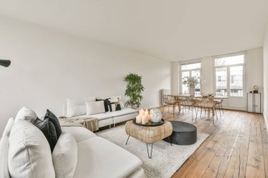 Modern apartmandaki dekorasyonlu ve televizyonlu, rahat koltuğun yanına yerleştirilmiş eski püskü ahşap masa.