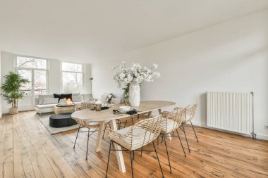 Modern apartmandaki dekorasyonlu ve televizyonlu, rahat koltuğun yanına yerleştirilmiş eski püskü ahşap masa.