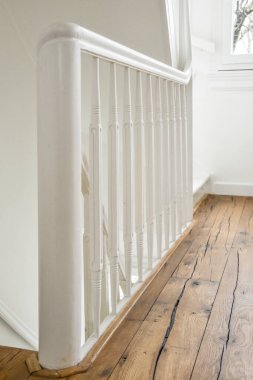 Dar sarmal merdivenlerin yukarısından, beyaz merdivenler ve modern dairenin duvarlarında parmaklıklar var.