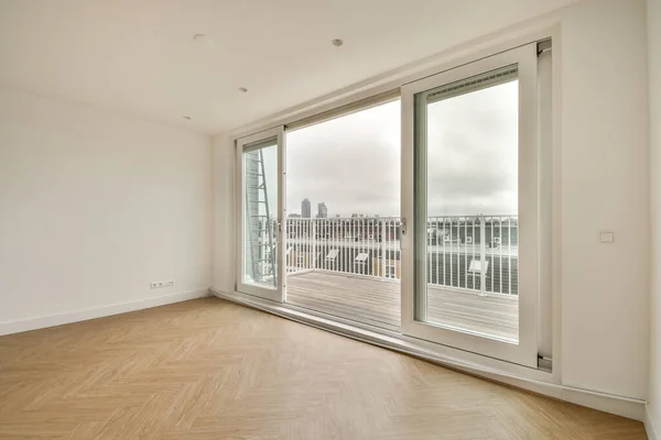 Interior of empty white room with windows and wooden parquet floor