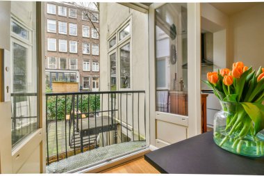 Oturma alanı ve ahşap çitlerin yanındaki küçük bahçesi olan düzgün asfaltlı bir avlu.