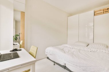 Boş tahtaya karşı bilgisayar monitörleri ile masanın yanına yerleştirilmiş rahat sandalye ve çağdaş düz ofis aynalı yatak