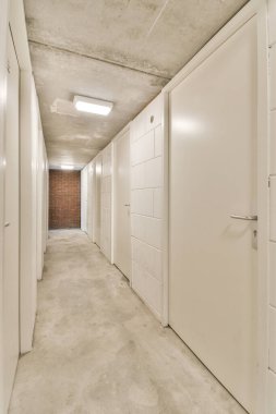 Işık dar koridor, beyaz duvarlarda birçok kapı ve kereste zemininde parlayan lamba