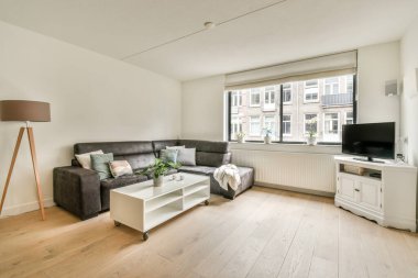 Günümüz minimalist tasarımı. Hafif stüdyo dairesinin ahşap masası ve oturma odası ile beyaz duvarları ve parke zemini arasında yemek masası ve sandalyeleri var.