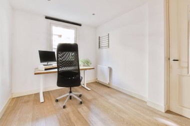 Boş tahtaya karşı bilgisayar monitörleri olan rahat sandalye ve çağdaş düz ev ofisinde ayna