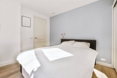 Yatak odasının iç tasarımı, yatak odası ve ahşap gardırop modern dairenin penceresinin kenarına yerleştirilmiş.