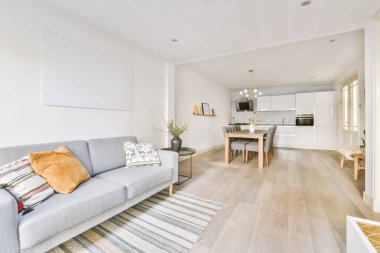 Çağdaş dairenin pencerelerine karşı rahat kanepesi ve televizyonu olan oturma odası.