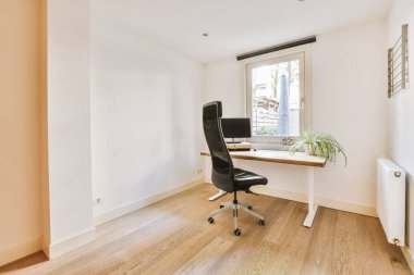 Boş tahtaya karşı bilgisayar monitörleri olan rahat sandalye ve çağdaş düz ev ofisinde ayna