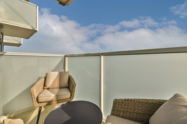 Güzel manzaralı rahat mobilyalarla balkonda oturma alanı