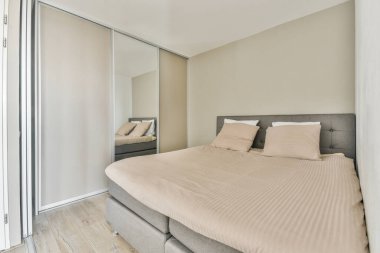 Kareli battaniyeyle kaplı rahat bir yatak ve modern dairenin aydınlık yatak odasında.