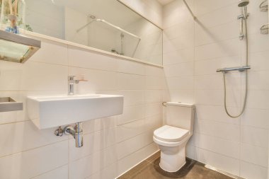 Lavabolu ve duvarlı, beyaz duvarlı ve kareli tuvaletli dar bir tuvalet.